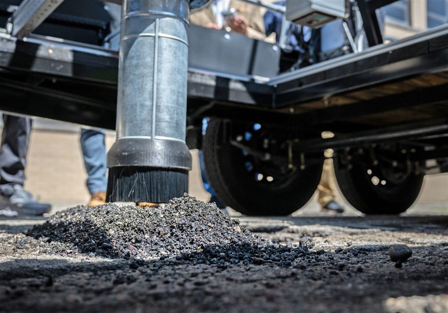 The Silly Surfacing robot's dispenser filling a pothole with asphalt during its demo
